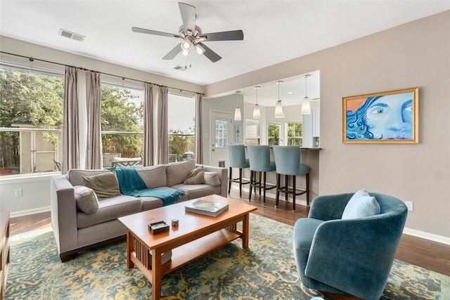 living area with visible vents, plenty of natural light, and wood finished floors