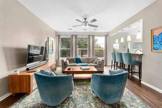 living room featuring ceiling fan and dark wood-type flooring