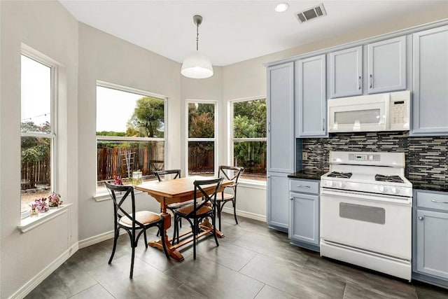 kitchen featuring visible vents, white appliances, dark countertops, and gray cabinetry