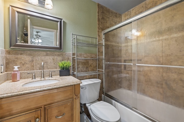 full bathroom featuring tile walls, vanity, toilet, and ceiling fan