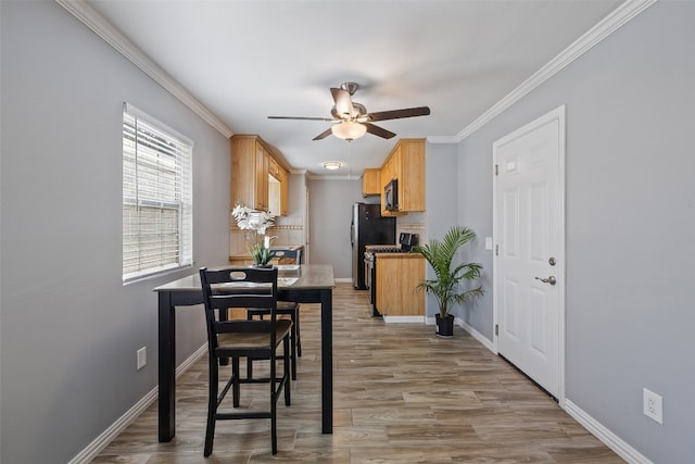 dining area with light hardwood / wood-style flooring, ceiling fan, and crown molding