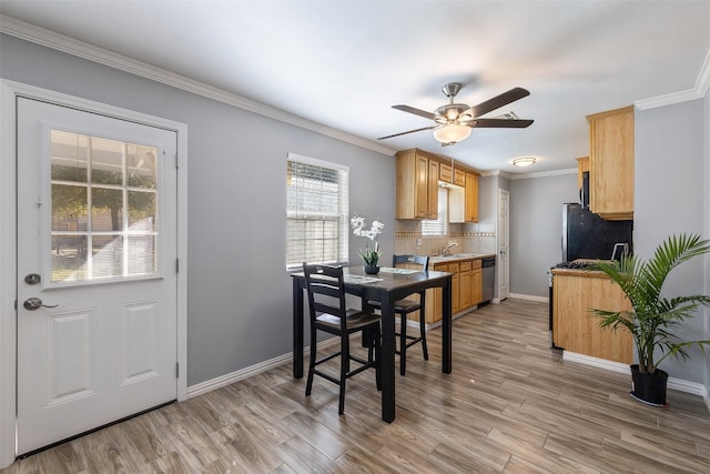 kitchen with ornamental molding, light hardwood / wood-style flooring, backsplash, and black refrigerator