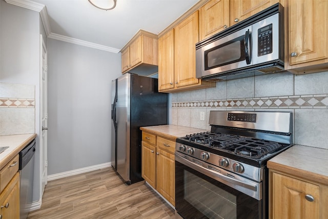 kitchen with stainless steel appliances, ornamental molding, light hardwood / wood-style flooring, and tasteful backsplash