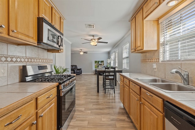 kitchen with appliances with stainless steel finishes, tile counters, and decorative backsplash