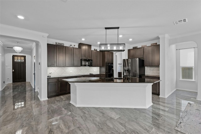 kitchen with decorative backsplash, crown molding, black appliances, a center island, and decorative light fixtures