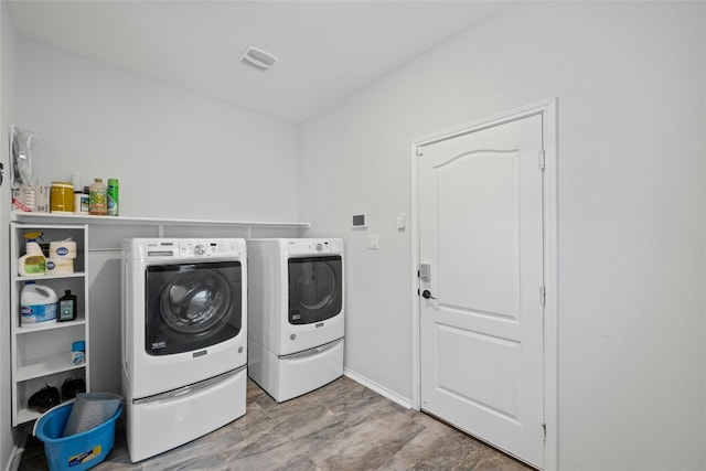 laundry room featuring washer and clothes dryer and light hardwood / wood-style floors