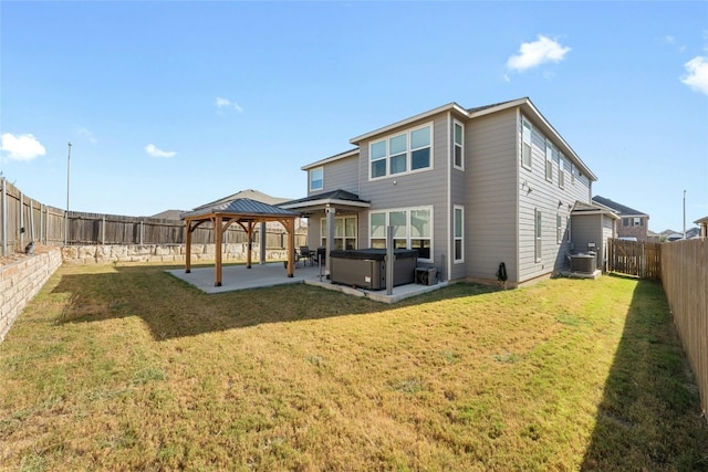 rear view of house featuring a hot tub, a yard, a patio, a gazebo, and central AC unit