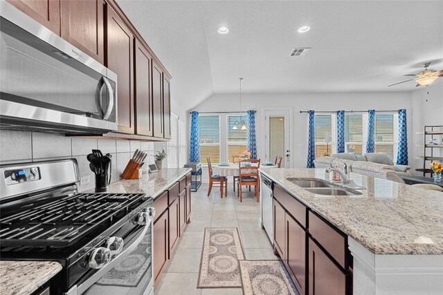 kitchen with appliances with stainless steel finishes, sink, pendant lighting, and a wealth of natural light