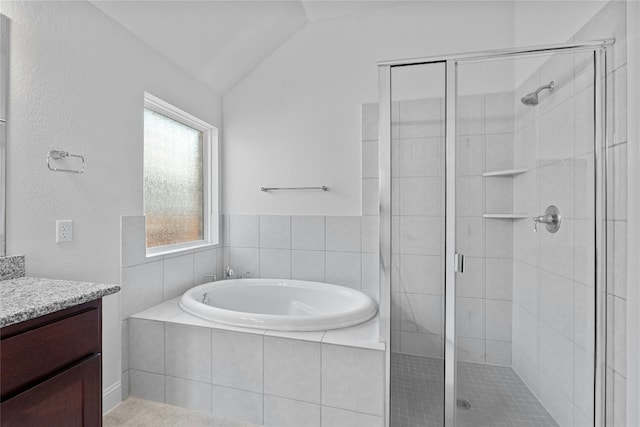 bathroom with vanity, vaulted ceiling, and separate shower and tub