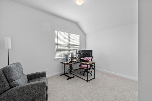 carpeted home office featuring vaulted ceiling