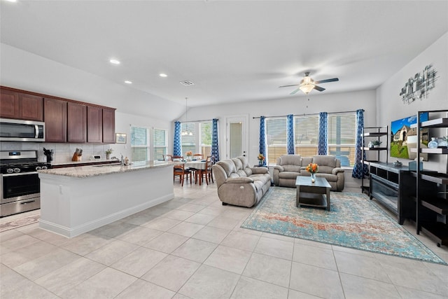 kitchen with light stone counters, ceiling fan, light tile patterned floors, sink, and stainless steel appliances