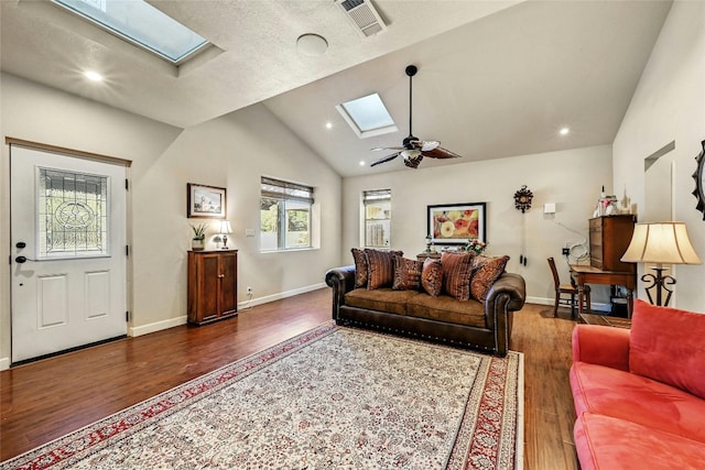 living room with lofted ceiling with skylight, ceiling fan, a textured ceiling, and dark hardwood / wood-style floors