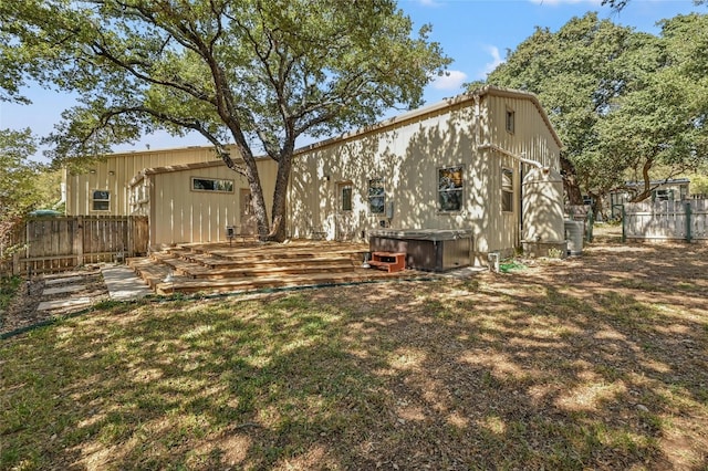 back of property featuring a wooden deck and a lawn