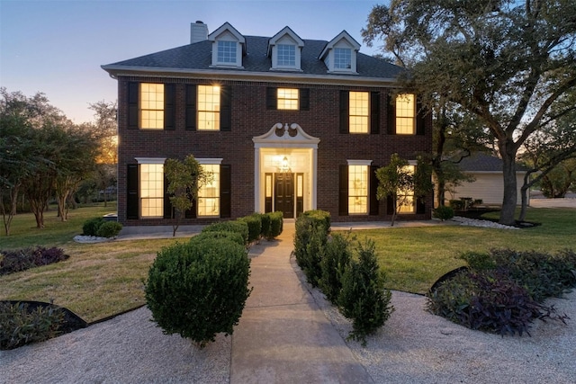 colonial-style house featuring a yard