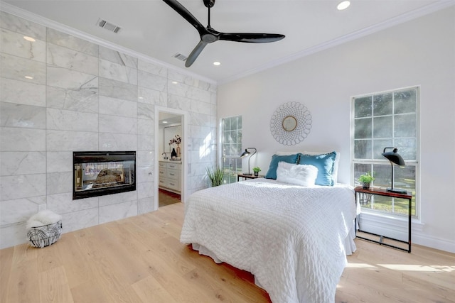 bedroom featuring light hardwood / wood-style floors, tile walls, ornamental molding, and ceiling fan