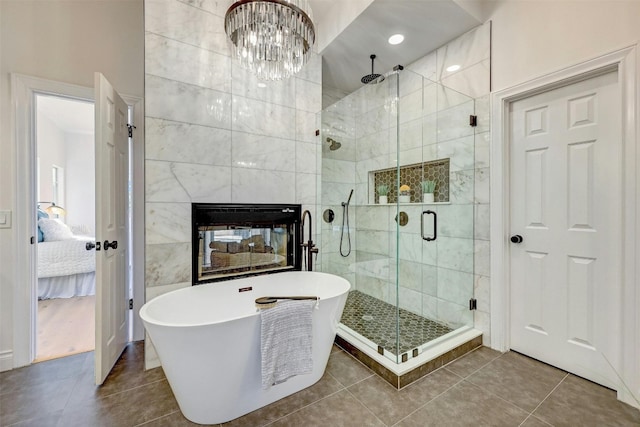 bathroom with tile walls, separate shower and tub, and tile patterned flooring