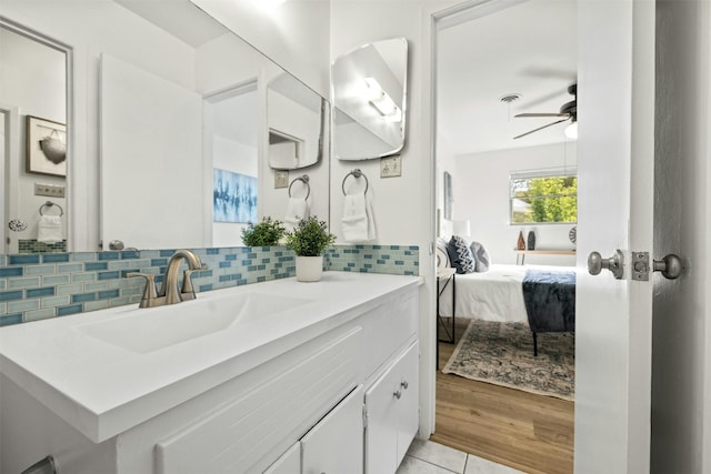 bathroom with vanity, ceiling fan, hardwood / wood-style flooring, and tasteful backsplash