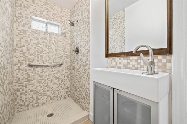 bathroom featuring vanity, decorative backsplash, tiled shower, and tile walls