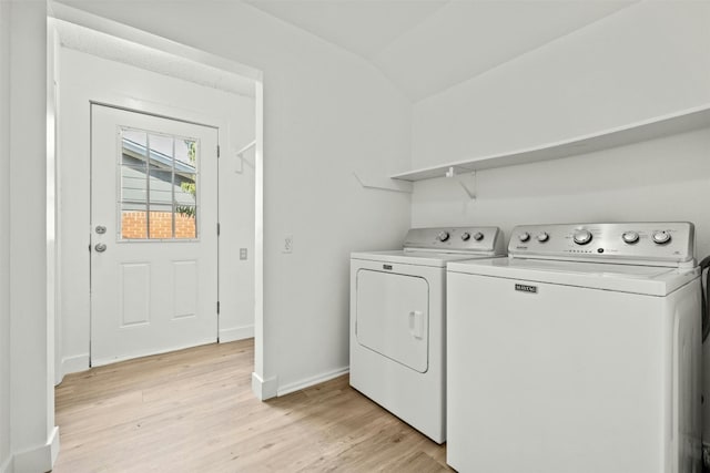 clothes washing area with light hardwood / wood-style flooring and washer and dryer