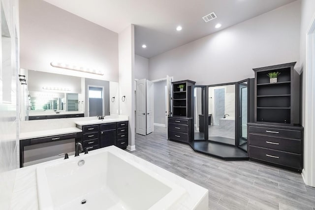 124 Park Place Dr, Georgetown, TX 78628 - full bathroom featuring a bath, wood finished floors, vanity, a shower, and recessed lighting