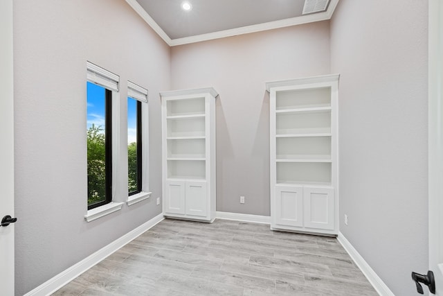 unfurnished room featuring light wood-type flooring and crown molding