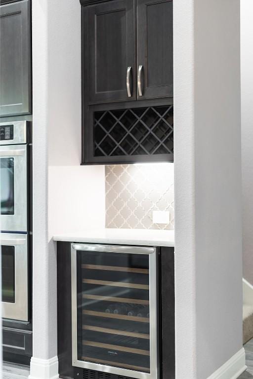 124 Park Place Dr, Georgetown, TX 78628 - indoor dry bar with wine cooler, stainless steel double oven, and tasteful backsplash