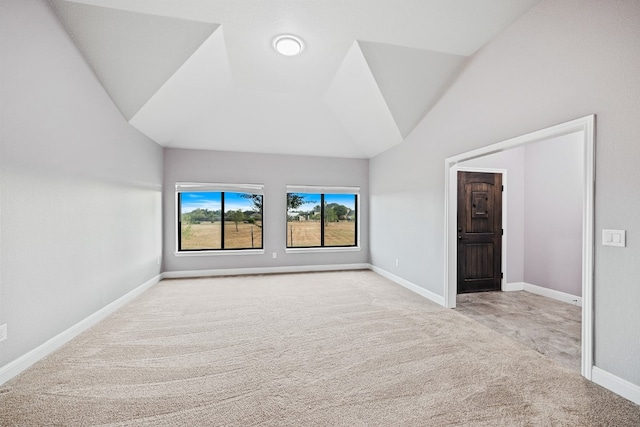 empty room featuring light carpet and vaulted ceiling