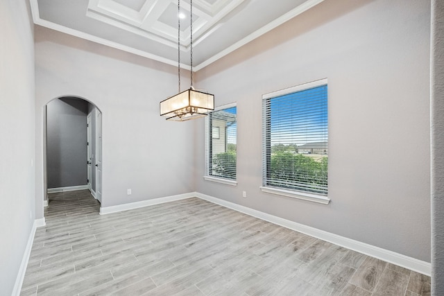 spare room with beamed ceiling, ornamental molding, light hardwood / wood-style flooring, and coffered ceiling