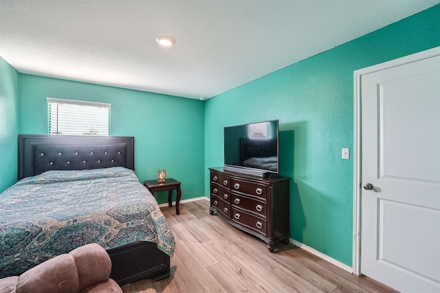 bedroom with light hardwood / wood-style flooring and a textured ceiling