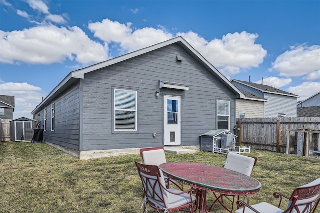 rear view of property with a shed and a yard