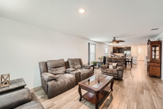 living room featuring ceiling fan and light hardwood / wood-style floors