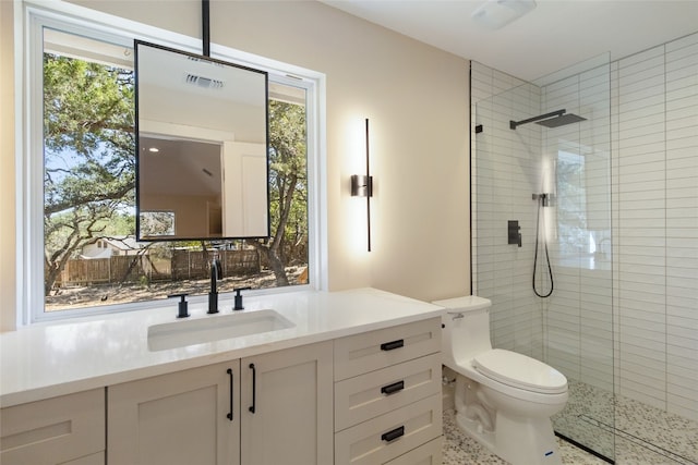 bathroom featuring vanity, toilet, and tiled shower