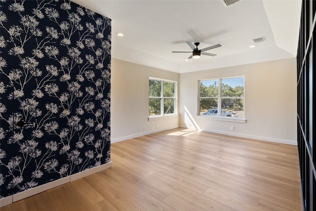 empty room with ceiling fan and light hardwood / wood-style flooring