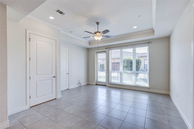 spare room featuring crown molding, a raised ceiling, light tile patterned floors, and ceiling fan