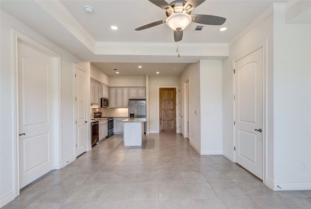 kitchen featuring light tile patterned floors, appliances with stainless steel finishes, ceiling fan, crown molding, and a center island