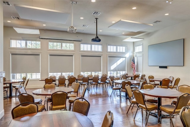 dining area featuring a wealth of natural light, a high ceiling, and hardwood / wood-style floors