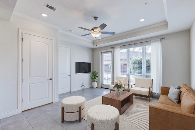 tiled living room featuring crown molding, a raised ceiling, and ceiling fan