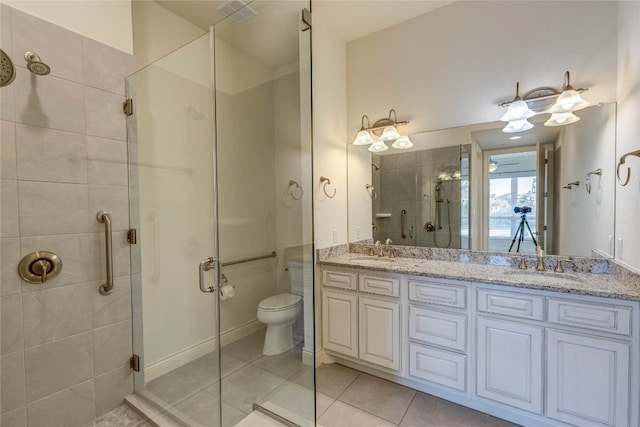 bathroom featuring vanity, tile patterned flooring, toilet, and walk in shower