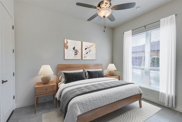 bedroom with multiple windows, light tile patterned floors, and ceiling fan