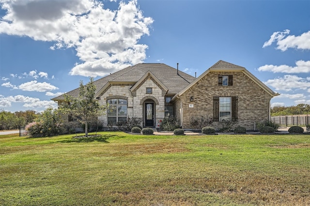 french country home with a front lawn