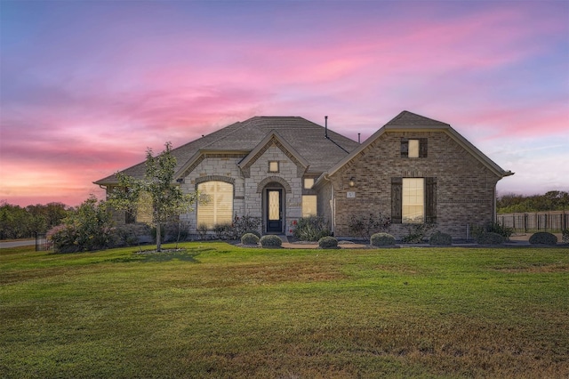 french country inspired facade with a yard