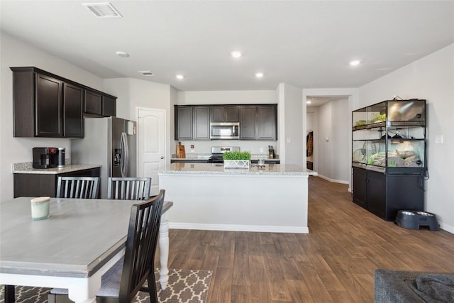 kitchen with dark hardwood / wood-style floors, dark brown cabinets, stainless steel appliances, and a center island