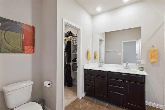 bathroom with hardwood / wood-style flooring, vanity, and toilet