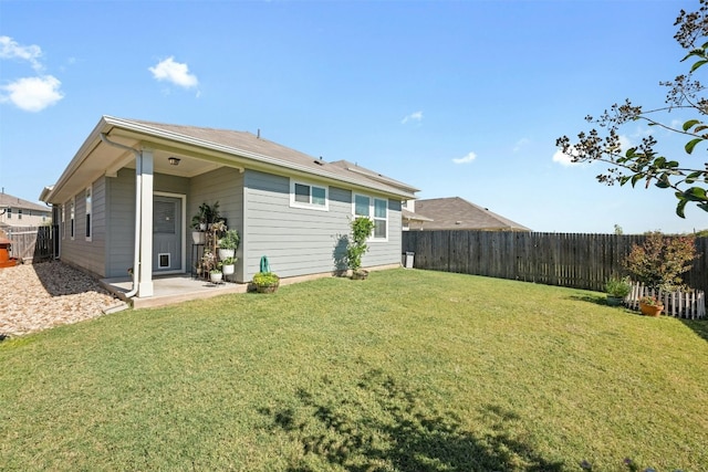 back of property featuring a lawn and a patio