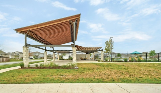 view of property's community with a pergola, a lawn, and a patio