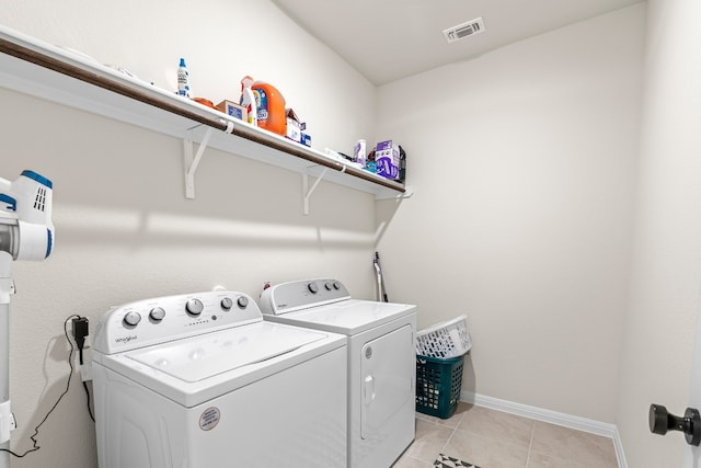 clothes washing area featuring independent washer and dryer and light tile patterned floors