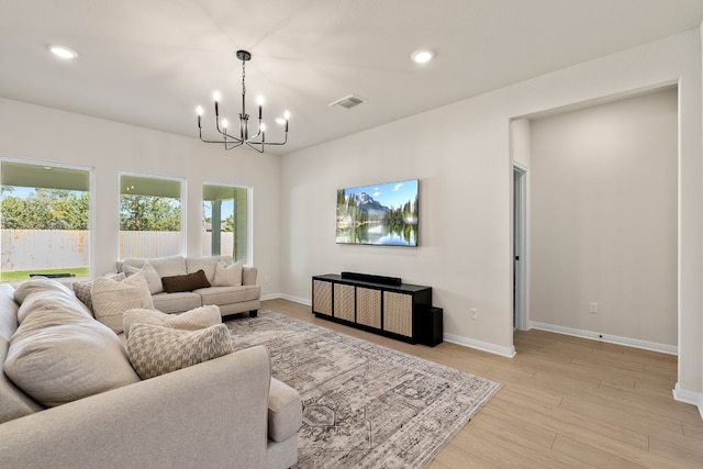 living room featuring light hardwood / wood-style flooring and an inviting chandelier