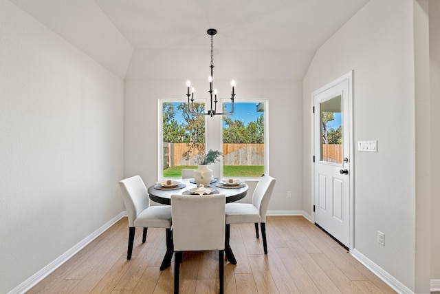 dining area featuring a notable chandelier, light hardwood / wood-style floors, and lofted ceiling