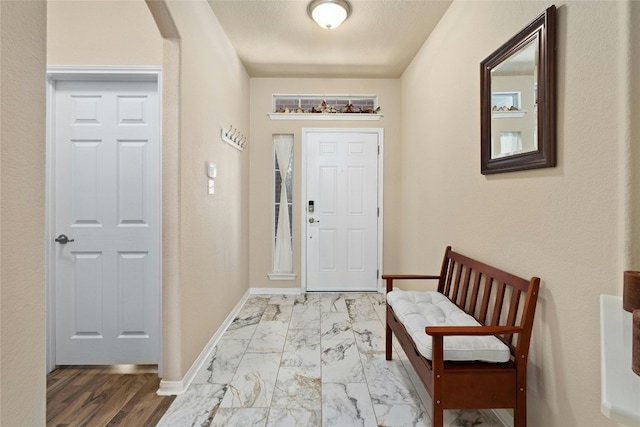 foyer entrance with a textured ceiling and light hardwood / wood-style flooring