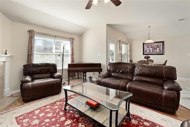 living room with light hardwood / wood-style floors, ceiling fan, plenty of natural light, and vaulted ceiling